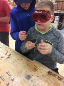 take TECH ED – Elementary Exploration -boy with safety googles at a workbench
